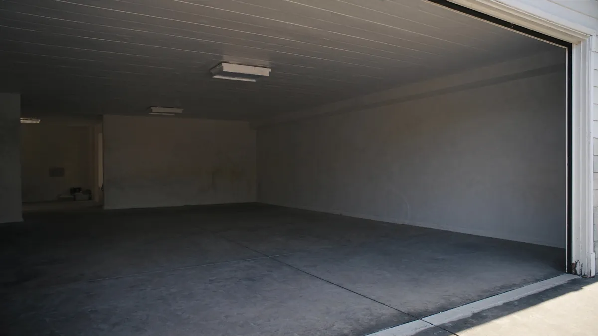 Intérieur d’un garage vide : le plafond doit rester libre vers le fond sur toute la course de la porte