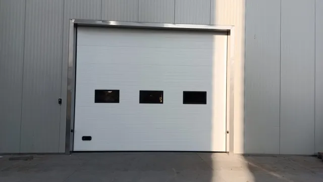 Porte de garage sectionnelle blanche avec trois hublots rectangulaires, installée sur une façade bardée
