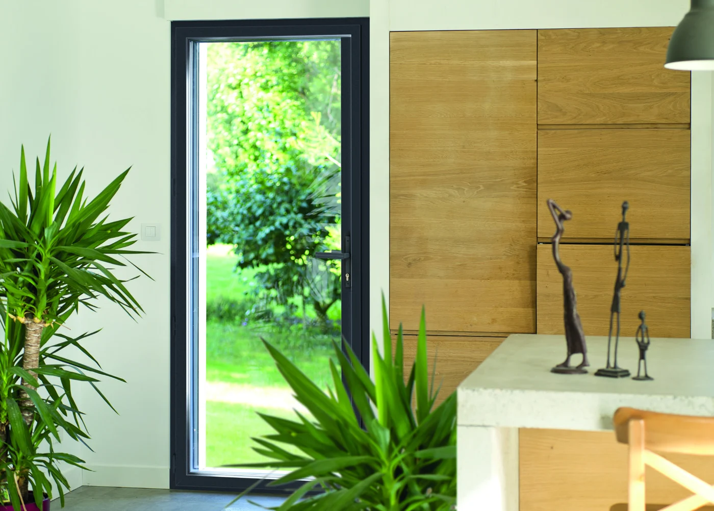 Menuiserie aluminium noire dans une salle de bains avec bois et végétation