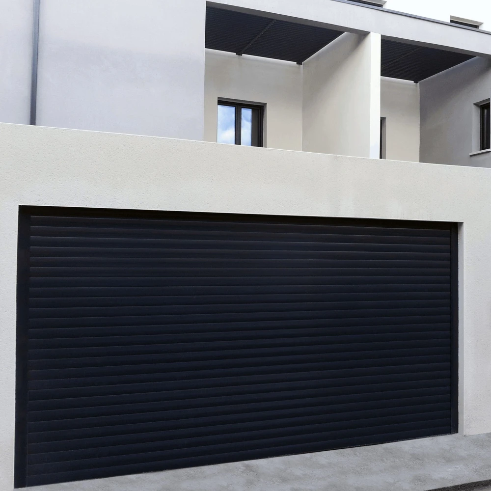 Porte de garage enroulable aluminium sombre fermée sous une façade blanche