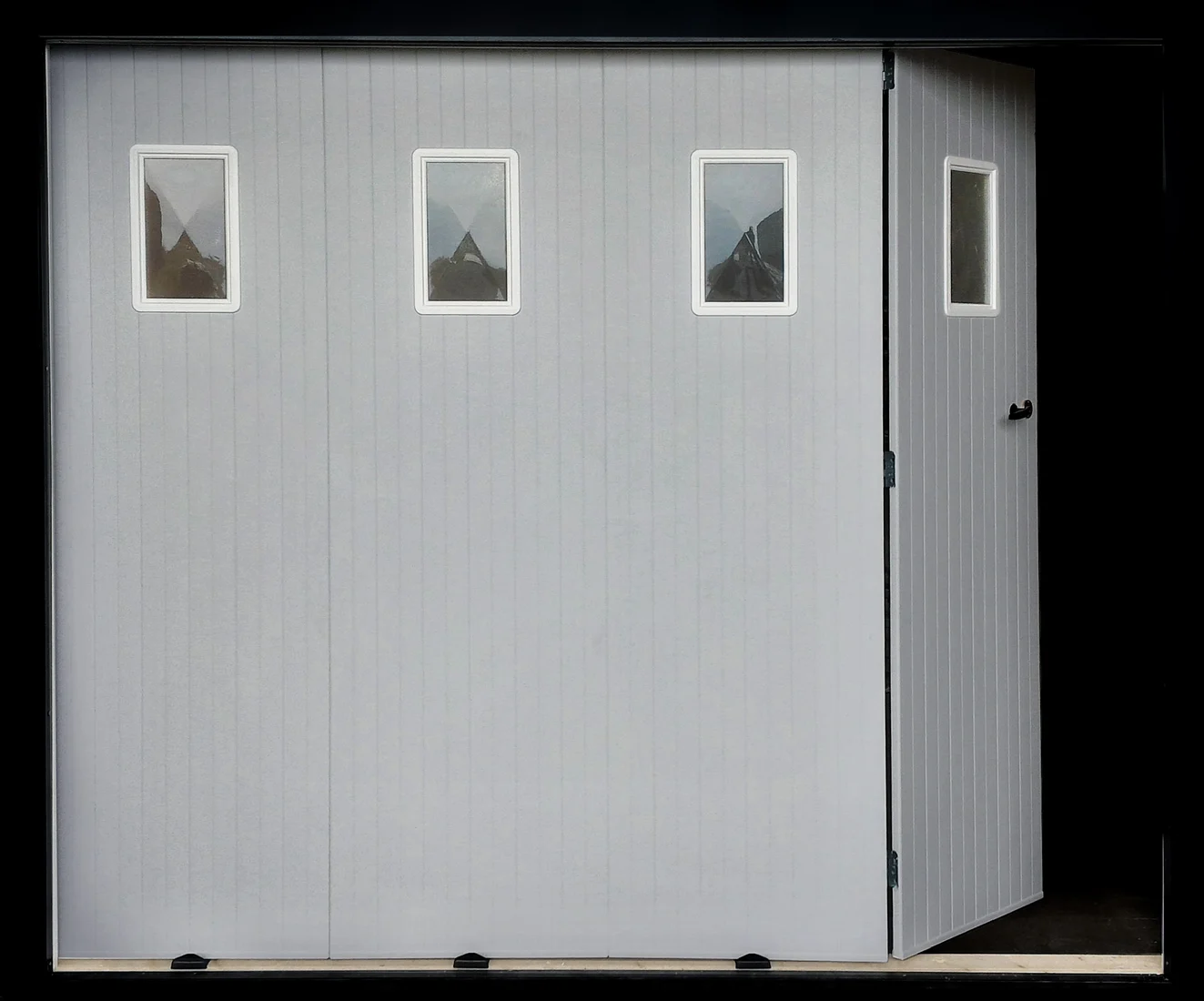 Porte de garage coulissante PVC · PVC gris · exemple avec hublots